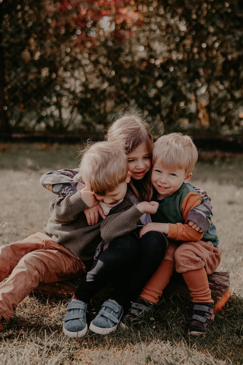 Drei Geschwisterkinder in der Kita