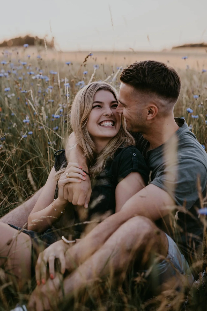 Pärchen sitzt in einer Wildblumenwiese